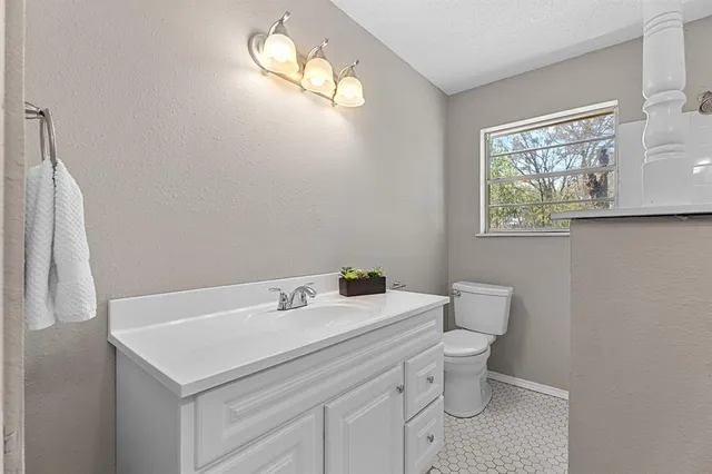 a bathroom with a sink a toilet and a window