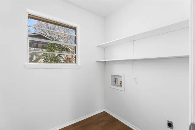 a view of small space with wooden floor and a window