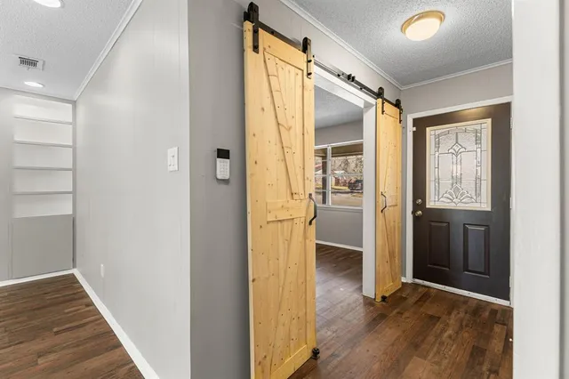 a view of a hallway with wooden floor and closet