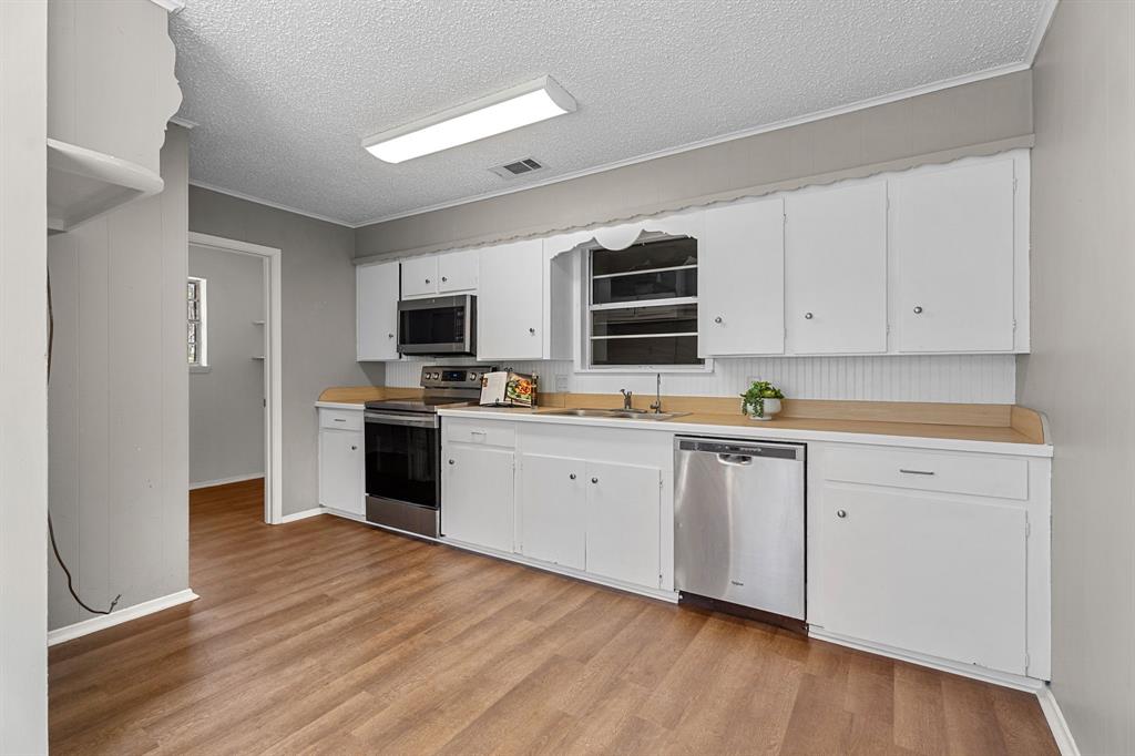685 Sides Circle Canton, TX 75103 - Photo 10 of 32 a kitchen with granite countertop a refrigerator stove top oven and sink