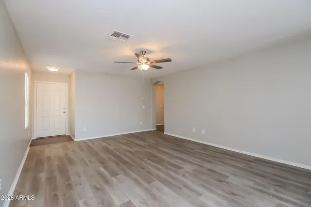 a view of an empty room with a chandelier fan