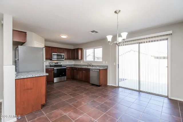 a large kitchen with a window and stainless steel appliances