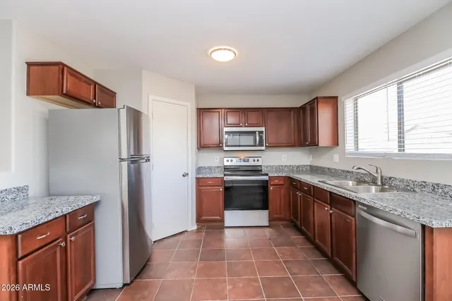a kitchen with stainless steel appliances granite countertop a refrigerator and a sink