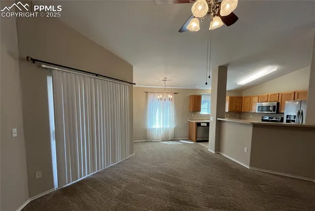 a view of a kitchen with a stove cabinets a ceiling fan and wooden floor