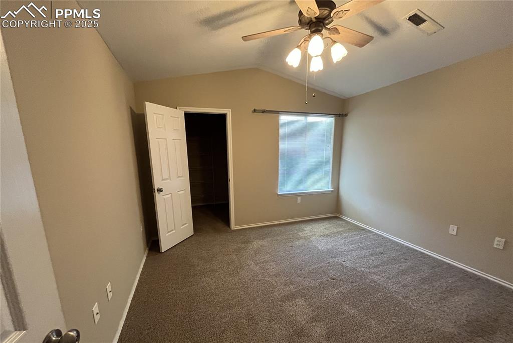 3927 Riviera Grove, Unit 203 Colorado Springs, CO 80922 - Photo 7 of 16 an empty room with closet and a chandelier fan