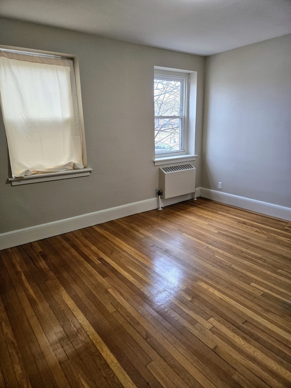 465 Arborway, Unit 13 Boston, MA 02130 - Photo 27 of 41 a view of an empty room with wooden floor and a window