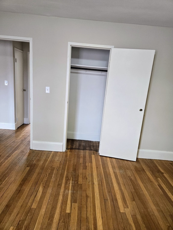 465 Arborway, Unit 13 Boston, MA 02130 - Photo 29 of 41 a view of an empty room with wooden floor and closet