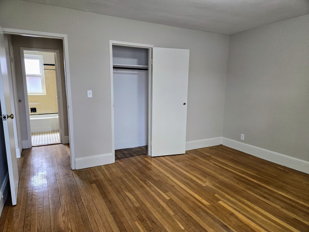 465 Arborway, Unit 13 Boston, MA 02130 - Photo 30 of 41 a view of an empty room and wooden floor