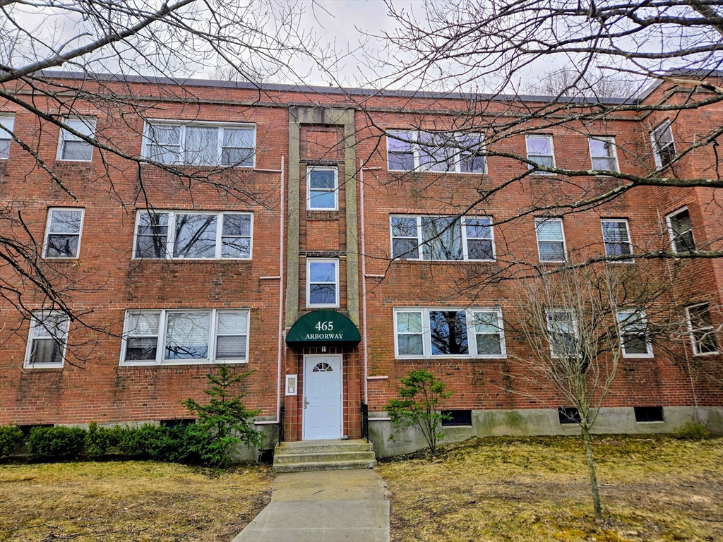 465 Arborway, Unit 13 Boston, MA 02130 - Photo 3 of 41 front view of a brick house with a yard