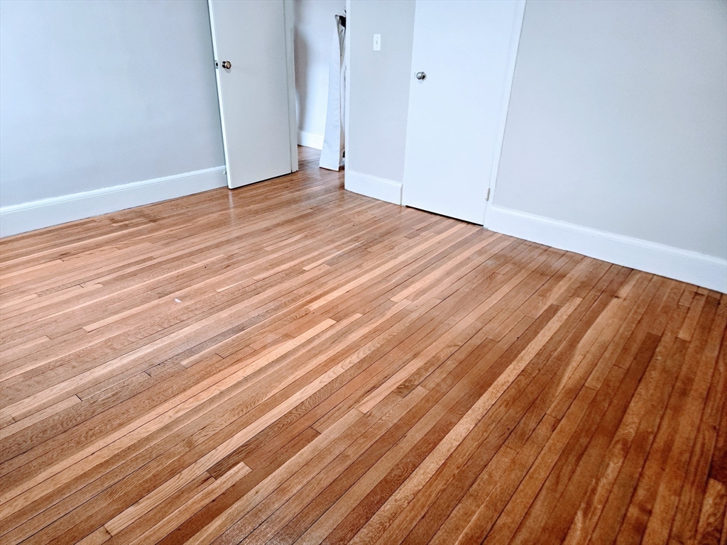 465 Arborway, Unit 13 Boston, MA 02130 - Photo 33 of 41 a view of room with wooden floor