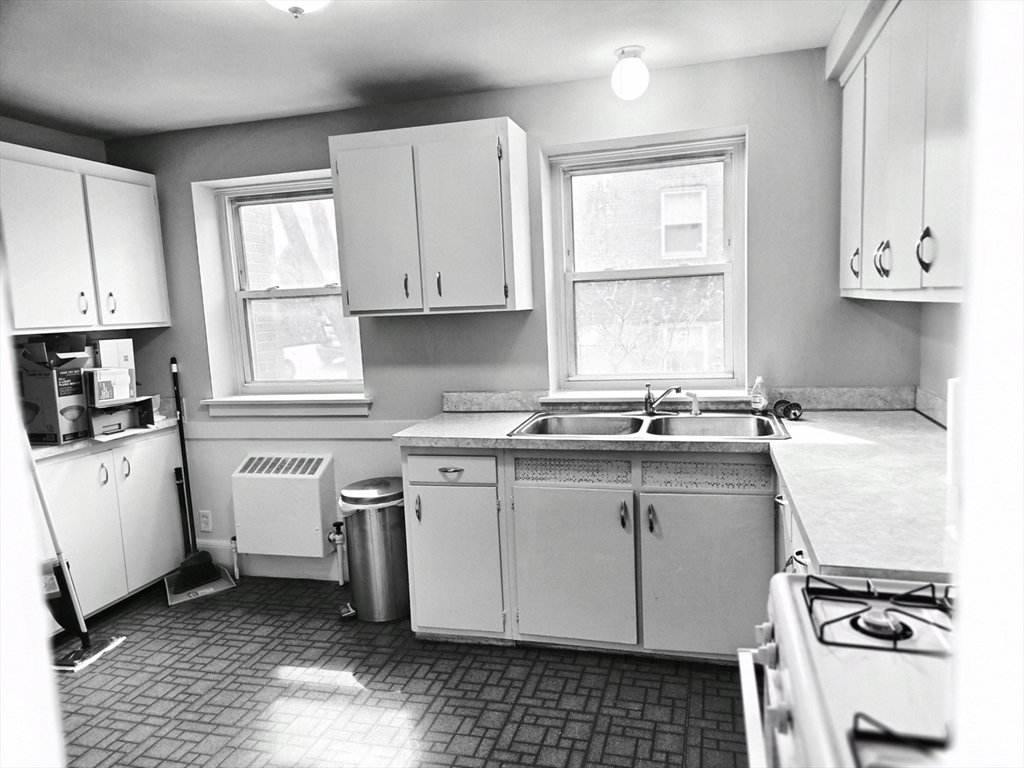 465 Arborway, Unit 13 Boston, MA 02130 - Photo 9 of 41 a kitchen with a sink stove and cabinets