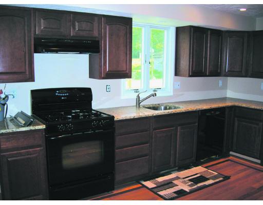 9 Cypress Road Groton, MA 01450 - Photo 3 of 13 a kitchen with granite countertop wood cabinets and a stove top oven