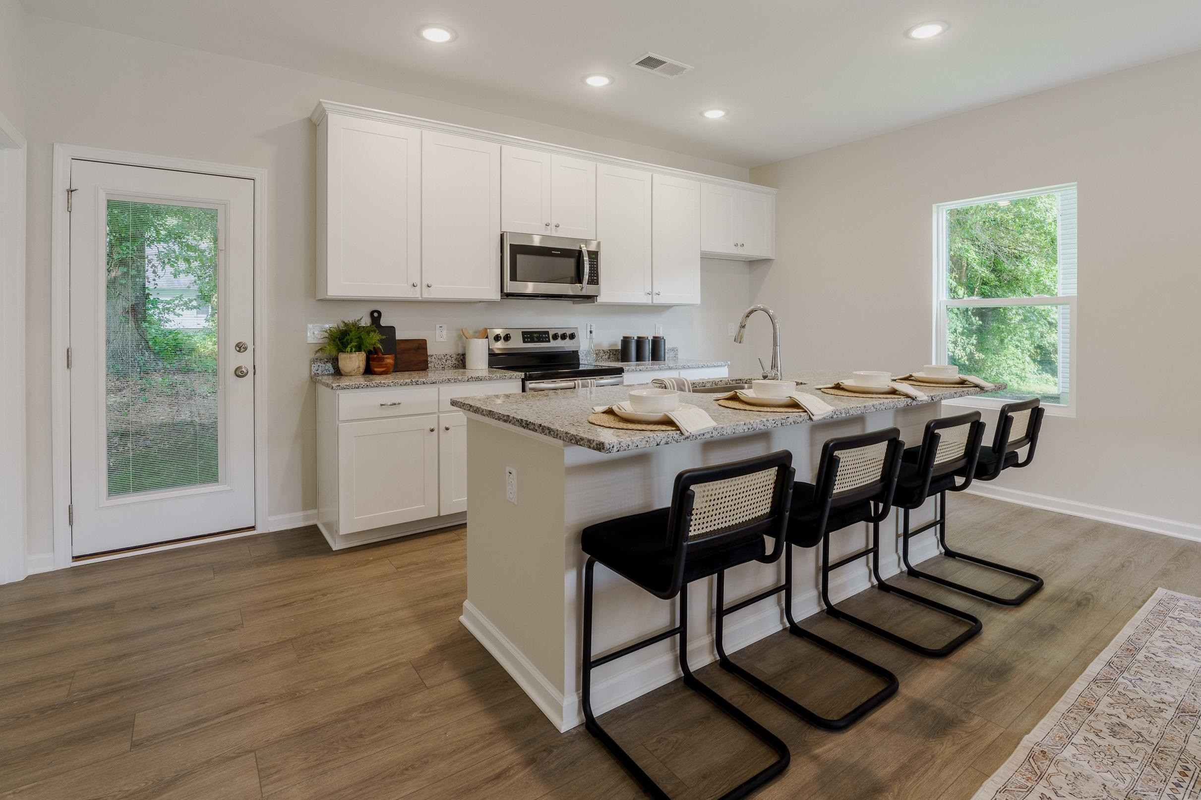 1309 Swingline Way Raleigh, NC 27610 - Photo 13 of 47 a kitchen with stainless steel appliances granite countertop a stove a sink a microwave refrigerator and white cabinets with wooden floor