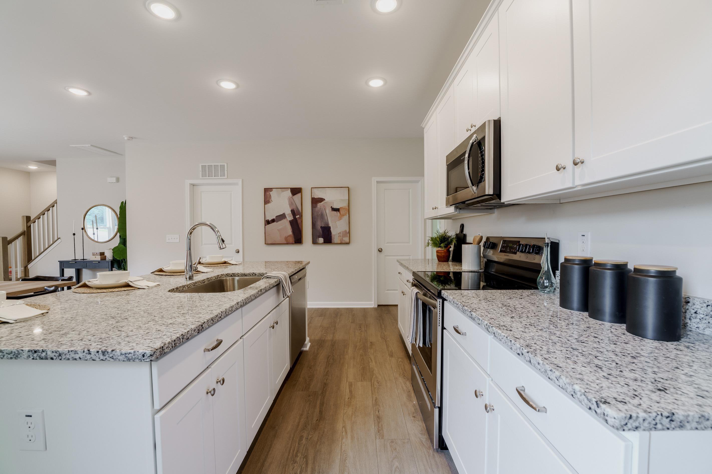 1309 Swingline Way Raleigh, NC 27610 - Photo 14 of 47 a kitchen with granite countertop a sink a stove and cabinets