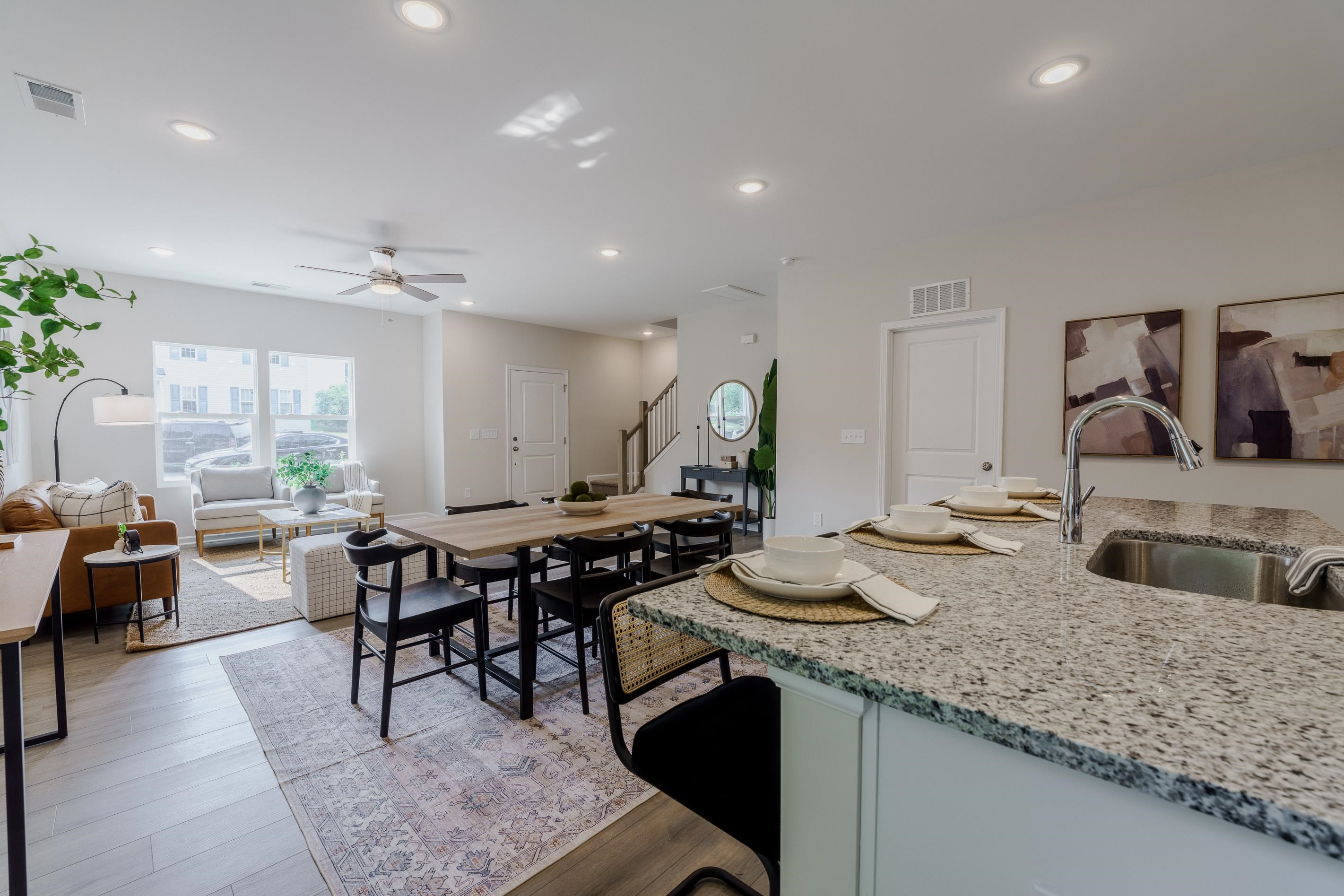 1309 Swingline Way Raleigh, NC 27610 - Photo 19 of 47 a kitchen with a stove a sink a dining table and chairs with wooden floor