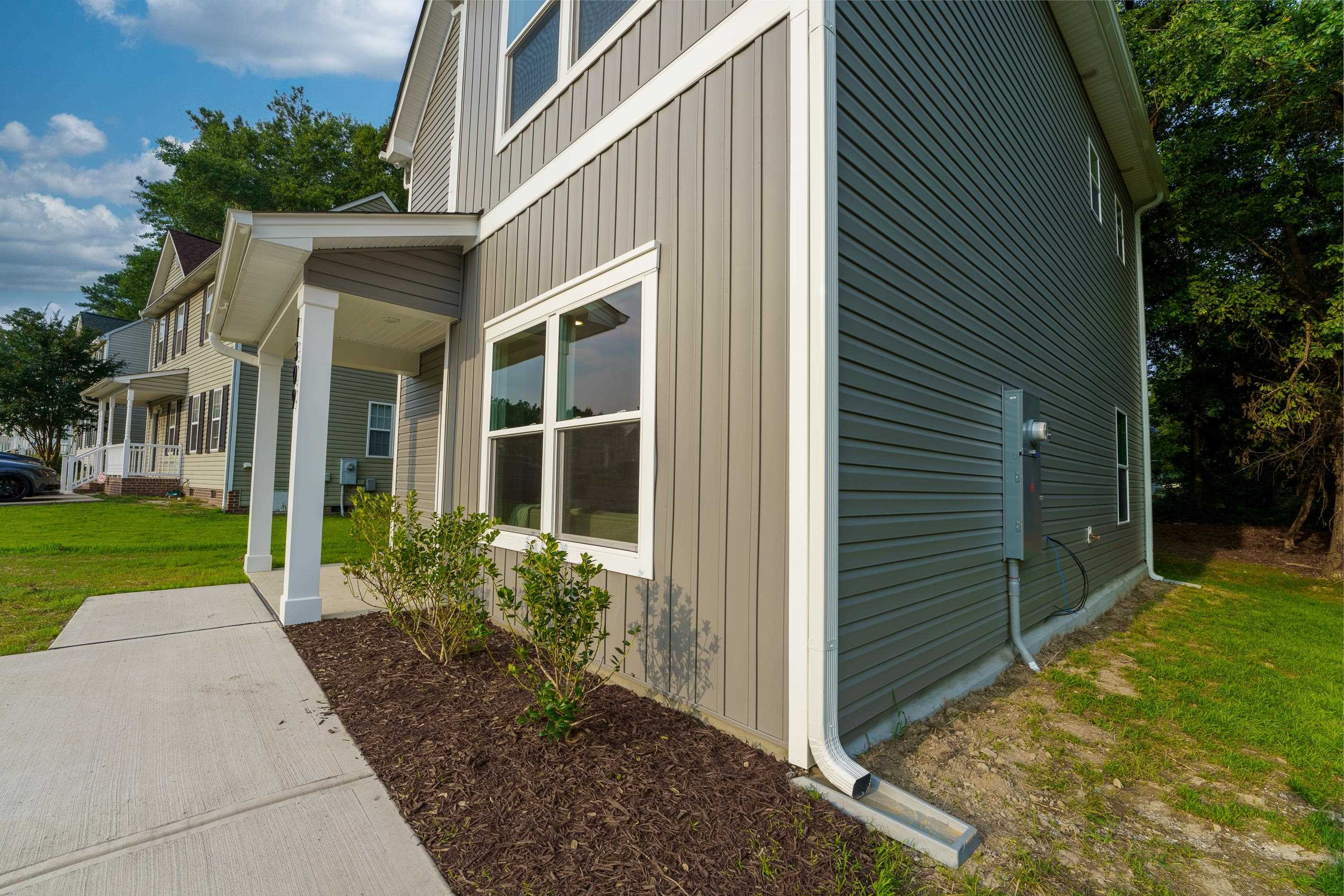 1309 Swingline Way Raleigh, NC 27610 - Photo 3 of 47 a view of a brick house with a yard plants and a large tree