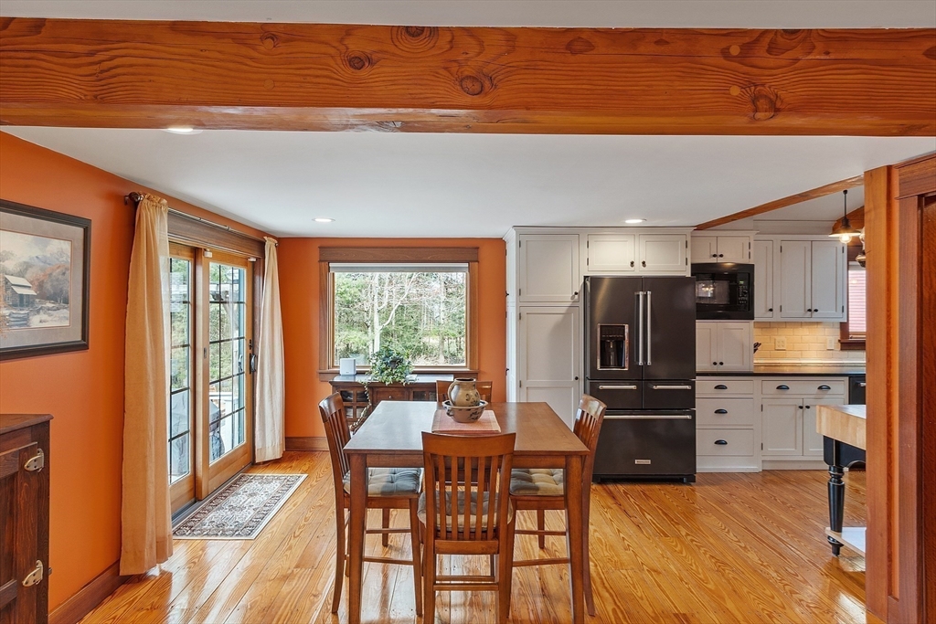 360 Teel Road Winchendon, MA 01475 - Photo 18 of 42 a kitchen with stainless steel appliances kitchen island granite countertop a refrigerator a stove a dining table and chairs with wooden floor