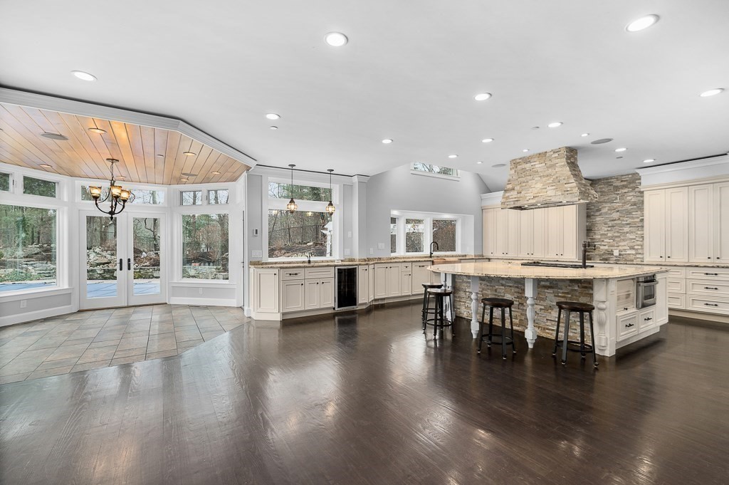 144 Grapevine Road Wenham, MA 01984 - Photo 6 of 42 a open kitchen with stainless steel appliances granite countertop a stove and kitchen island next to a large window