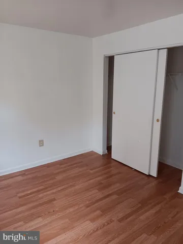 an empty room with wooden floor and entrance