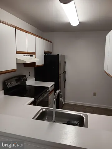 a kitchen with a sink a refrigerator and cabinets