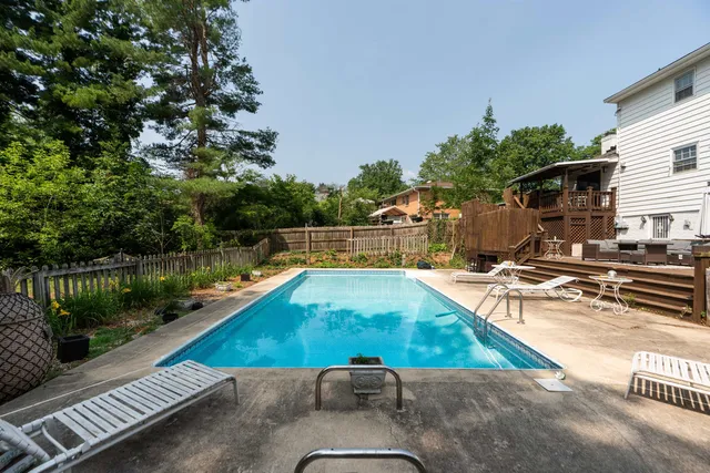 a backyard of a house with wooden floor fence and outdoor seating