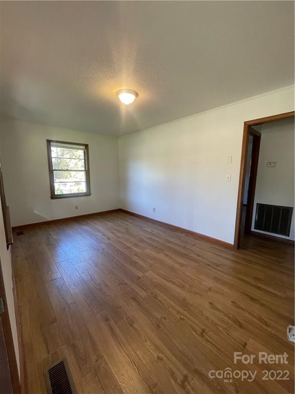 3538 Rudisill Road Newton, NC 28658 - Photo 6 of 20 a view of an empty room with wooden floor and a window