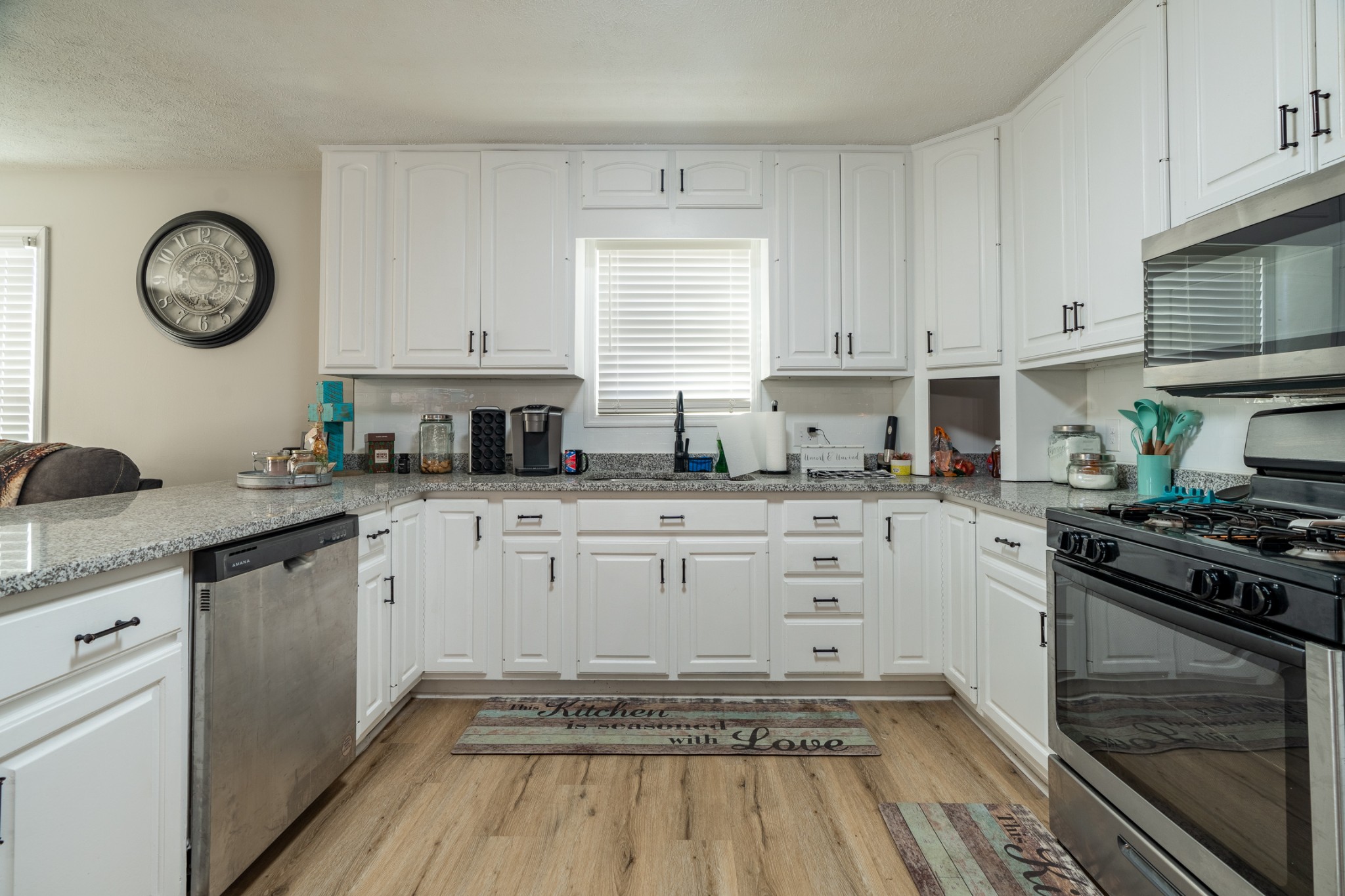 1727 Johnson Chapel Road Sparta, TN 38583 - Photo 7 of 30 a kitchen with granite countertop a stove a sink dishwasher and white cabinets with wooden floor