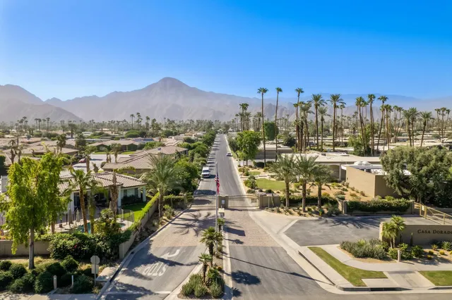 a view of a swimming pool with a lawn chairs under an umbrella