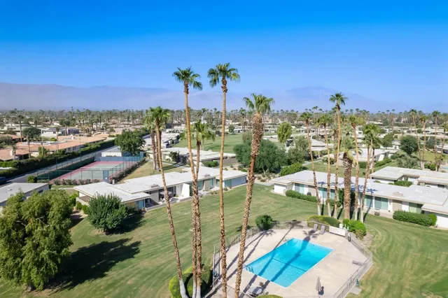 an aerial view of residential houses with outdoor space and swimming pool