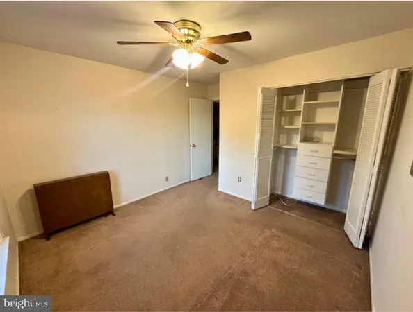 a view of room with closet and ceiling fan