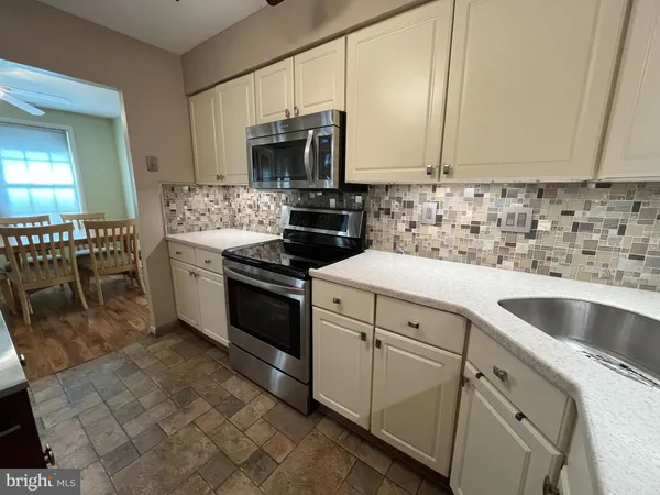 a kitchen with white cabinets sink and stainless steel appliances