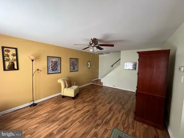 a view of a livingroom with wooden floor and workspace