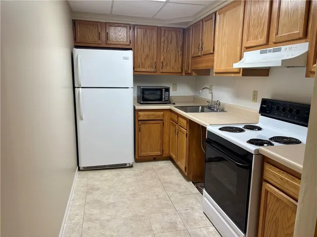 a kitchen with a refrigerator sink stove and cabinets
