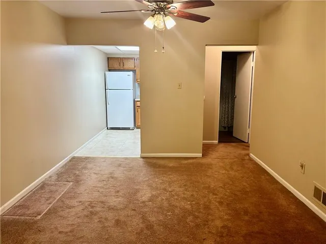 an empty room with closet and a chandelier fan