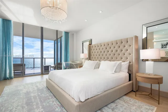 a bedroom with a large bed and a chandelier