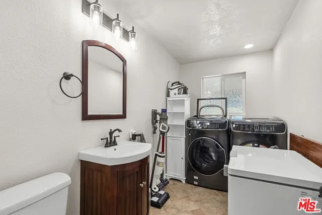 a utility room with sink dryer and washer