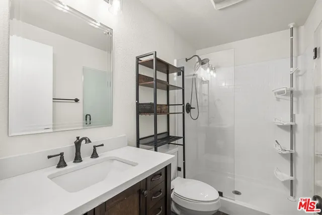 a bathroom with a sink toilet vanity and shower