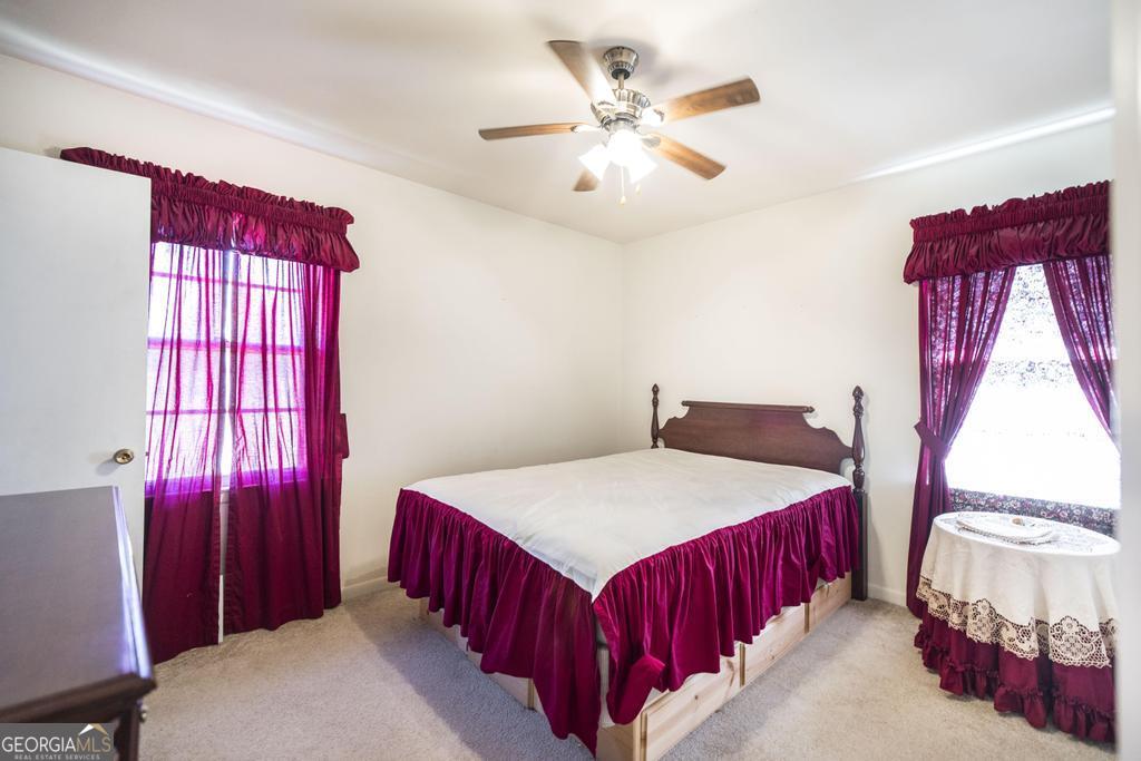 172 Old Eastman Road Cochran, GA 31014 - Photo 17 of 60 a bedroom with a bed and a chandelier