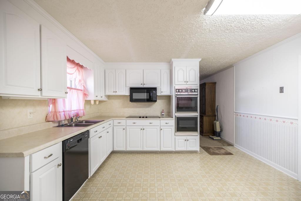 172 Old Eastman Road Cochran, GA 31014 - Photo 28 of 60 a kitchen with granite countertop a sink stainless steel appliances and cabinets