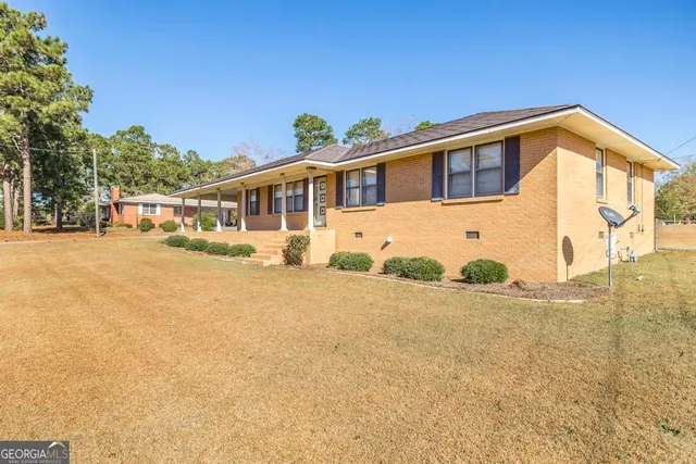 a front view of a house with a yard and potted plants