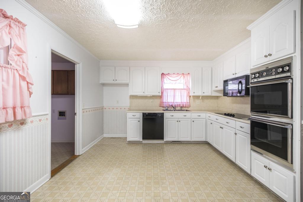 172 Old Eastman Road Cochran, GA 31014 - Photo 31 of 60 a kitchen with granite countertop white cabinets and stainless steel appliances