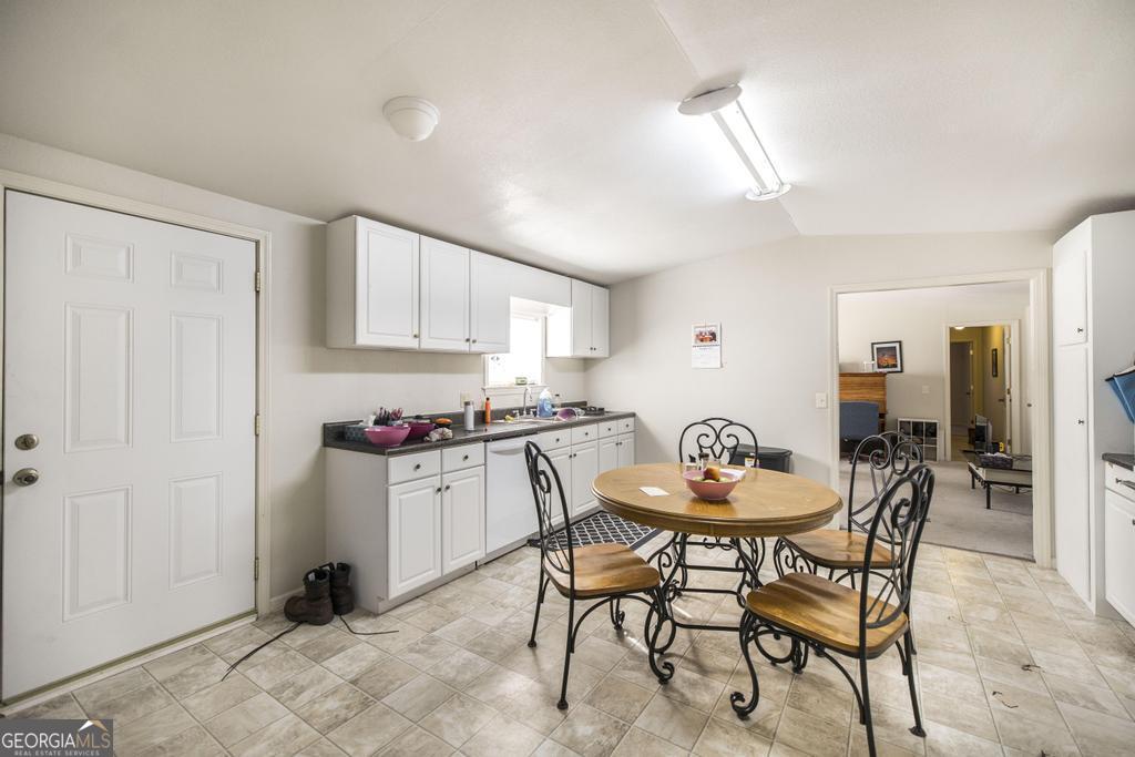 172 Old Eastman Road Cochran, GA 31014 - Photo 58 of 60 a kitchen with a dining table chairs and white cabinets