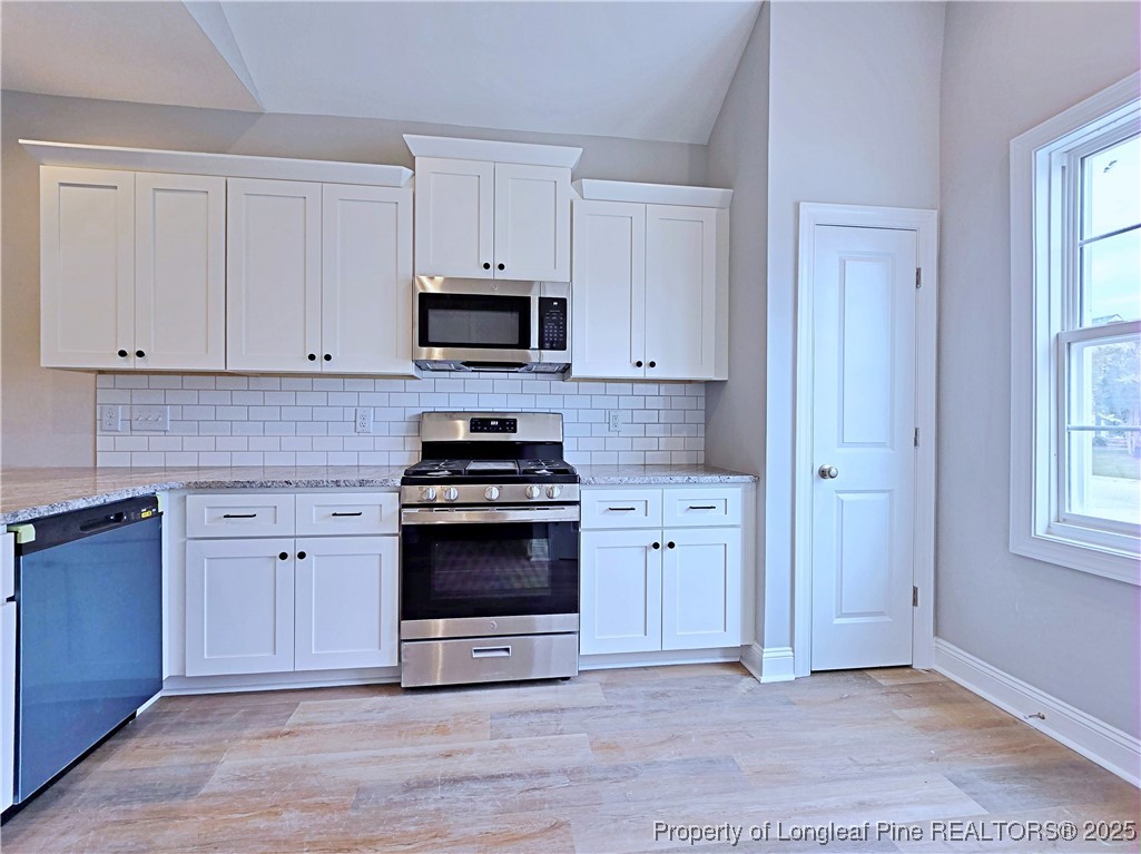 940 Kensington Park Road Fayetteville, NC 28311 - Photo 12 of 41 a kitchen with white cabinets and stainless steel appliances