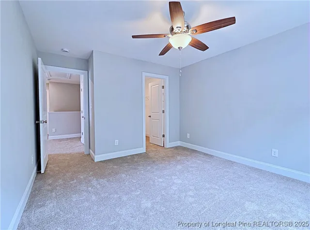 an empty room with closet and a chandelier fan