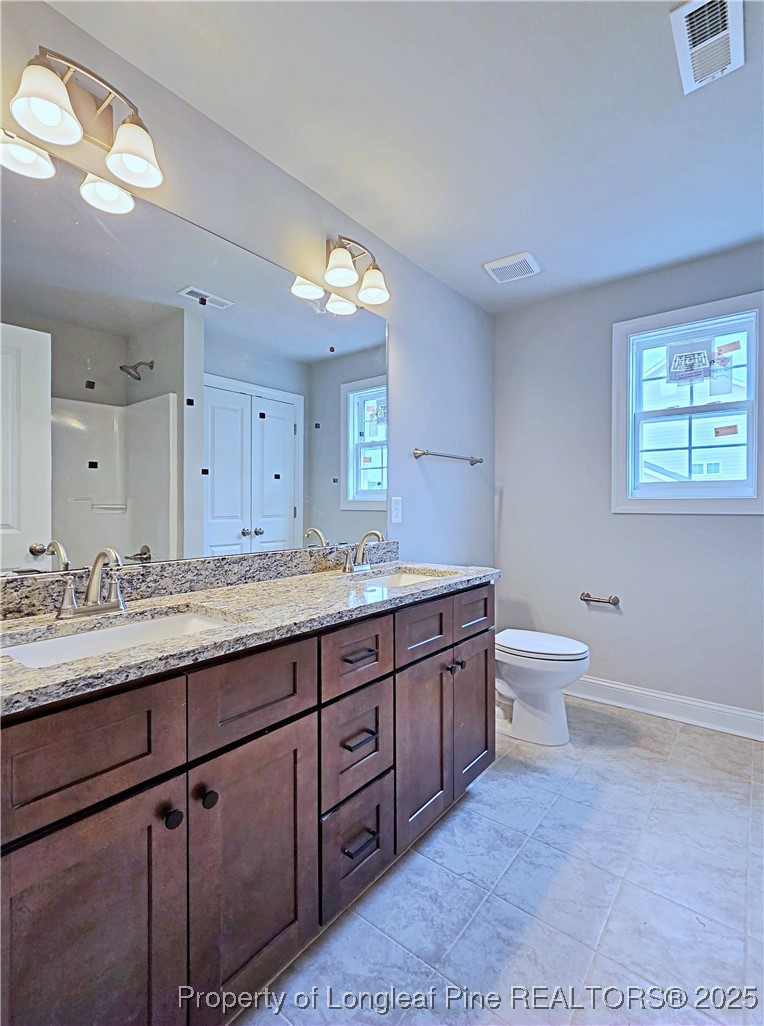 940 Kensington Park Road Fayetteville, NC 28311 - Photo 28 of 41 a bathroom with a granite countertop toilet sink and mirror