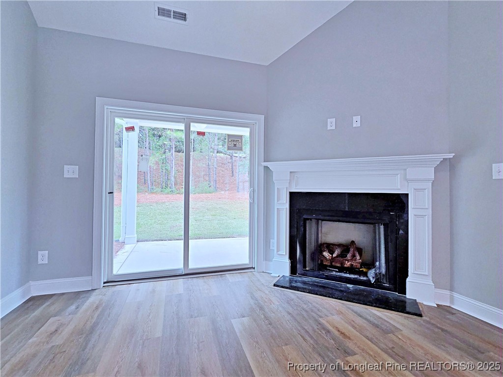940 Kensington Park Road Fayetteville, NC 28311 - Photo 3 of 38 a living room with a fireplace with a floor to ceiling window and a fireplace
