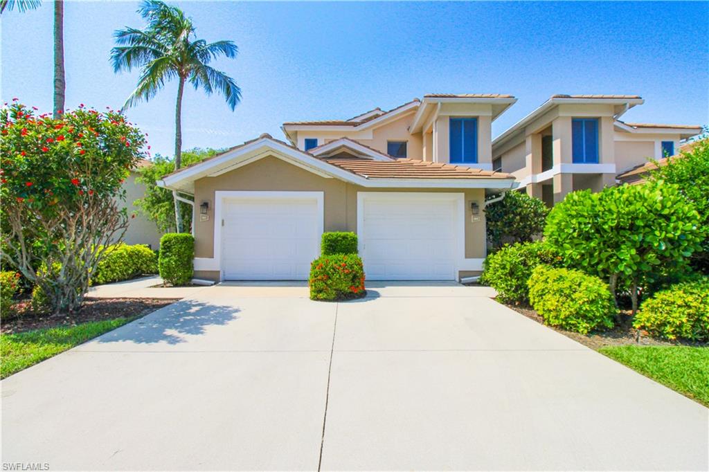 817 Carrick Bend Circle, Unit 101 Naples, FL 34110 - Photo 1 of 49 a front view of a house with a yard and garage