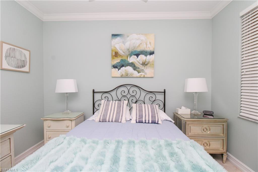 817 Carrick Bend Circle, Unit 101 Naples, FL 34110 - Photo 16 of 49 a bedroom with a bed and a painting on the wall