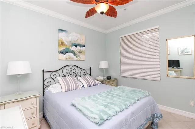 a bedroom with a large bed and a lamp on dresser