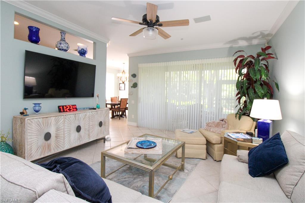 817 Carrick Bend Circle, Unit 101 Naples, FL 34110 - Photo 19 of 49 a living room with furniture and a flat screen tv